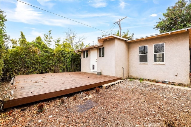 rear view of property featuring a wooden deck