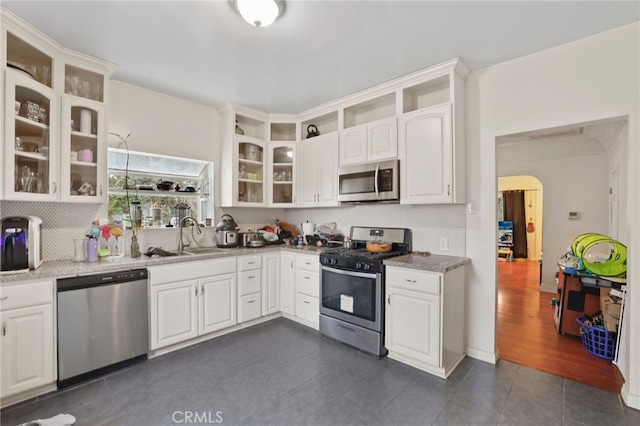 kitchen featuring sink, white cabinetry, tasteful backsplash, appliances with stainless steel finishes, and light stone countertops