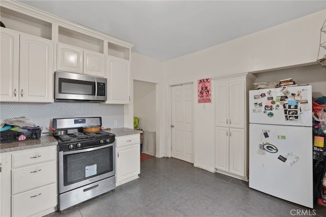 kitchen featuring stainless steel appliances, white cabinets, stone counters, and decorative backsplash