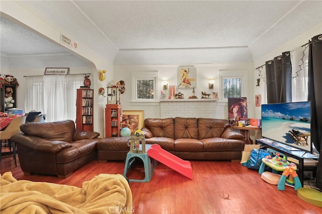 living room with hardwood / wood-style floors, ornamental molding, and a textured ceiling