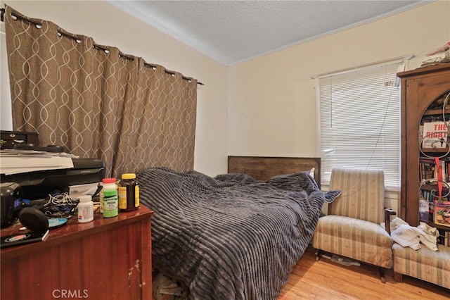 bedroom featuring a textured ceiling and light hardwood / wood-style floors