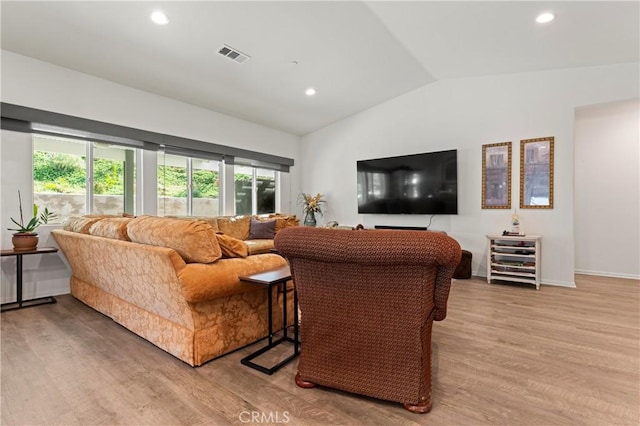 living room featuring vaulted ceiling and light hardwood / wood-style floors