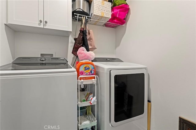 washroom featuring cabinets and washer and dryer