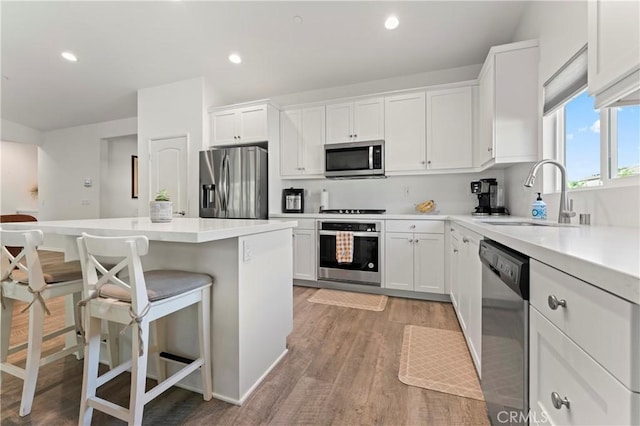 kitchen featuring white cabinetry, appliances with stainless steel finishes, a breakfast bar, and sink