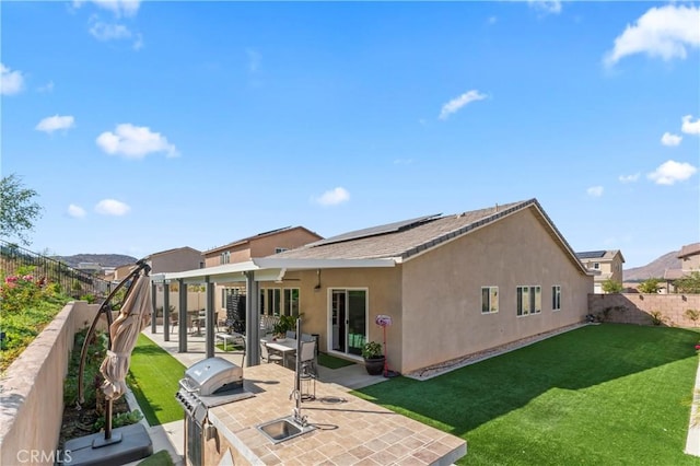 rear view of house with a yard and a patio