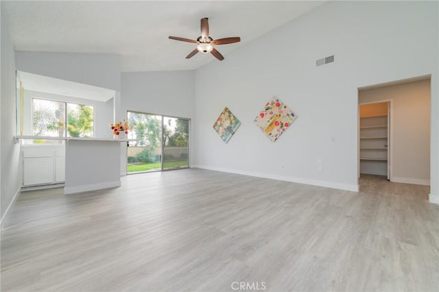 unfurnished living room with ceiling fan, high vaulted ceiling, and light hardwood / wood-style flooring