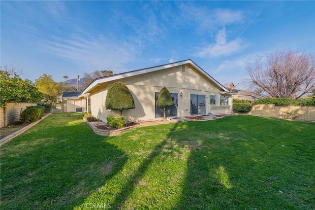 rear view of property featuring a lawn