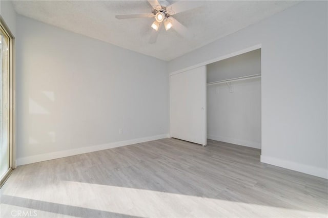 unfurnished bedroom featuring a textured ceiling, a closet, ceiling fan, and light wood-type flooring