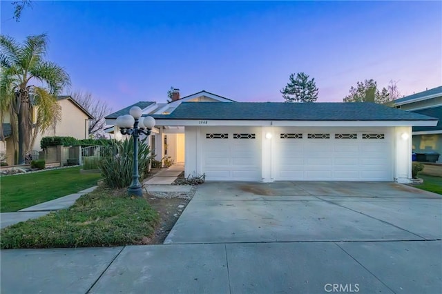 view of front of property with a garage and a yard