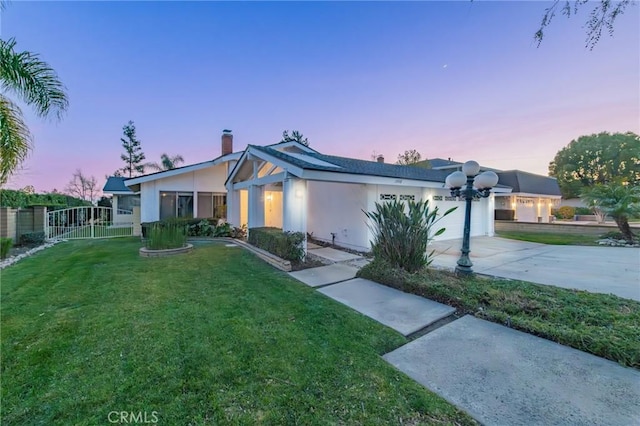 ranch-style house featuring a garage and a lawn