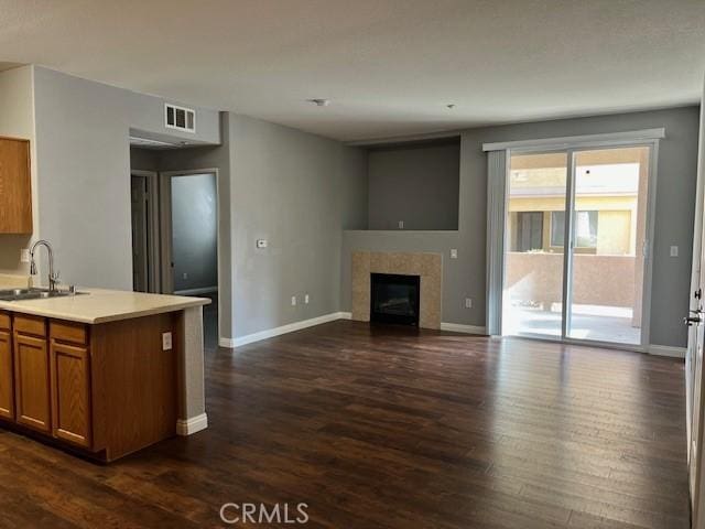 kitchen featuring dark hardwood / wood-style flooring, sink, and a fireplace