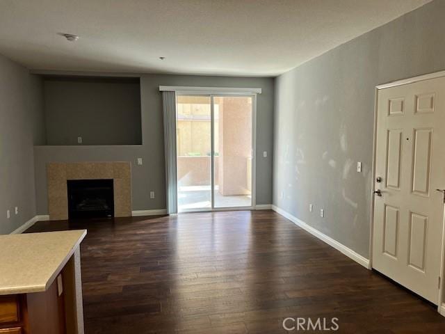 unfurnished living room featuring a fireplace and dark wood-type flooring