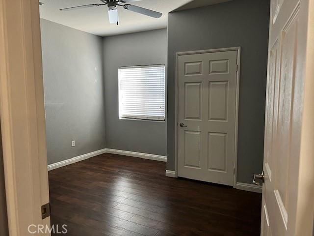 unfurnished bedroom with ceiling fan and dark hardwood / wood-style flooring