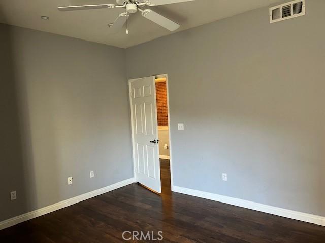 spare room featuring ceiling fan and dark hardwood / wood-style floors