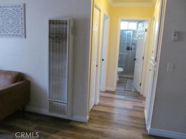 hallway featuring ornamental molding and dark hardwood / wood-style floors