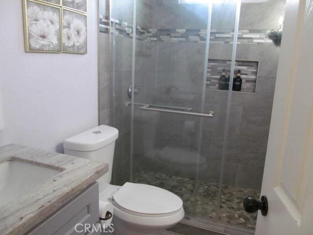 bathroom with vanity, toilet, and walk in shower