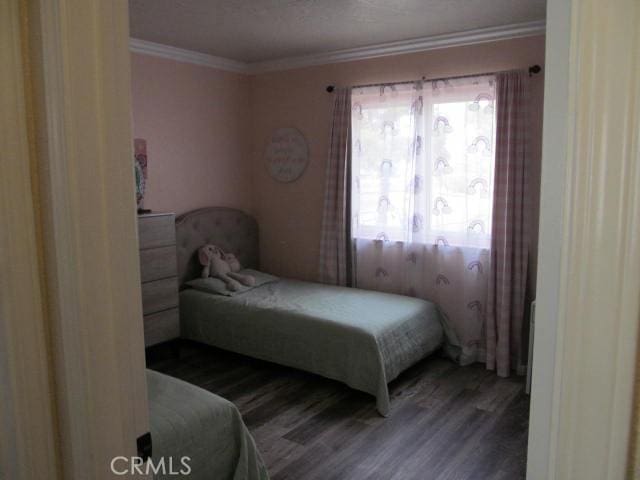 bedroom with wood-type flooring and ornamental molding