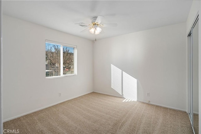 spare room featuring light colored carpet and ceiling fan