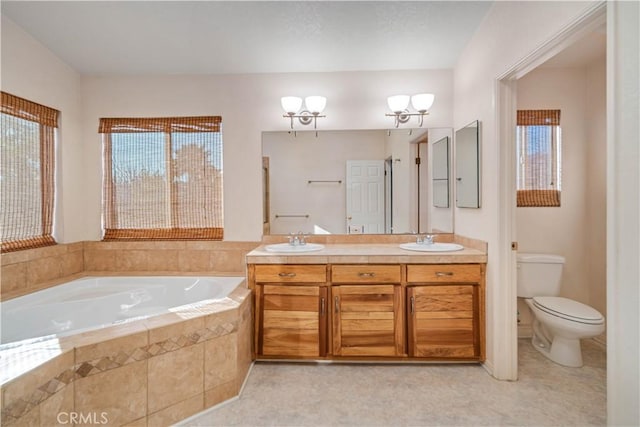 bathroom with an inviting chandelier, vanity, a relaxing tiled tub, a healthy amount of sunlight, and toilet