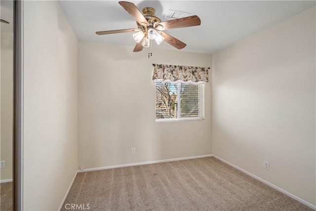 carpeted spare room with ceiling fan