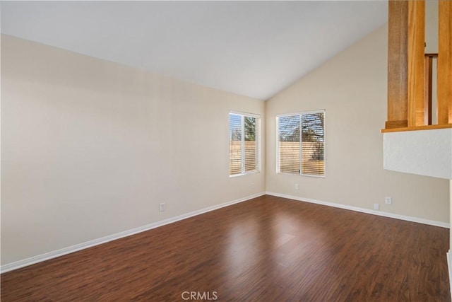 empty room featuring dark wood-type flooring and vaulted ceiling