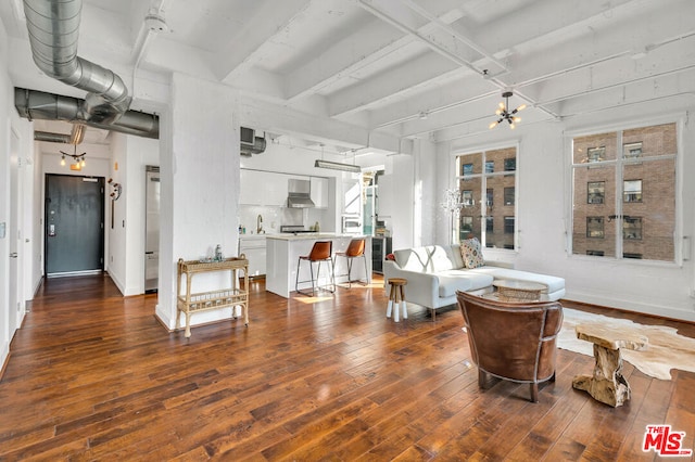 living room with dark wood-type flooring, sink, and beamed ceiling