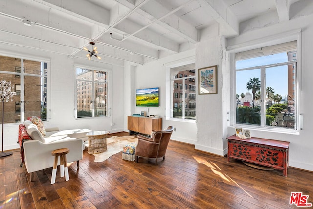 living room with beamed ceiling, a chandelier, and dark hardwood / wood-style flooring