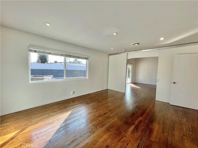 spare room featuring hardwood / wood-style flooring and a wealth of natural light