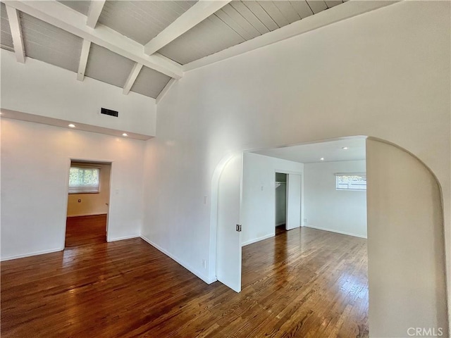 unfurnished room featuring beamed ceiling, dark hardwood / wood-style floors, and high vaulted ceiling