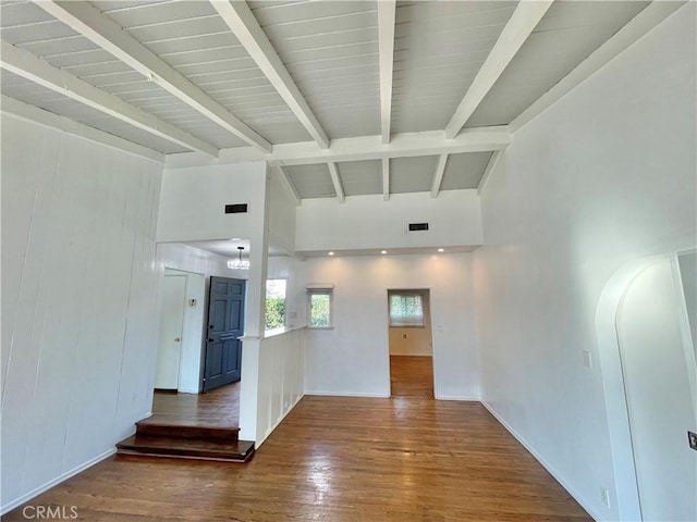 empty room with lofted ceiling with beams and wood-type flooring