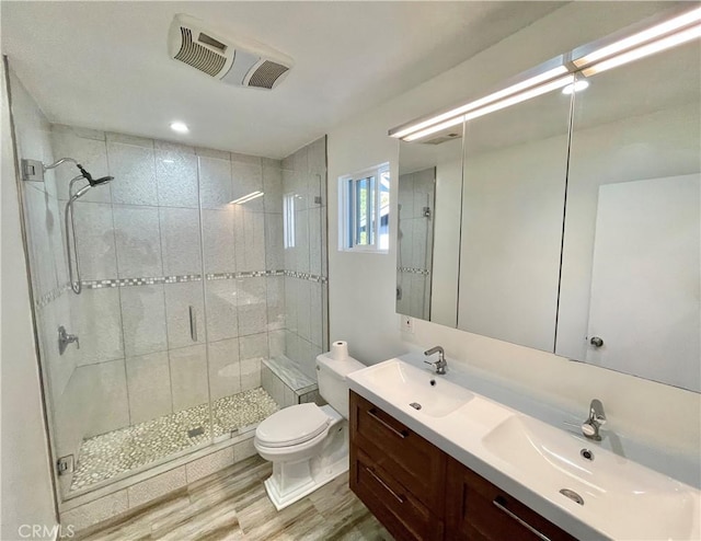 bathroom featuring vanity, wood-type flooring, toilet, and walk in shower