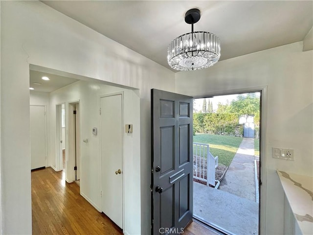 entryway featuring an inviting chandelier and dark hardwood / wood-style flooring