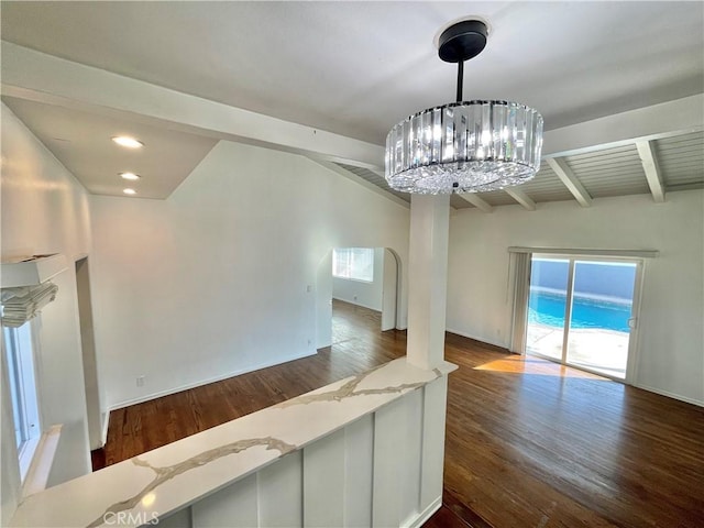 unfurnished living room with beamed ceiling, dark hardwood / wood-style floors, and a chandelier