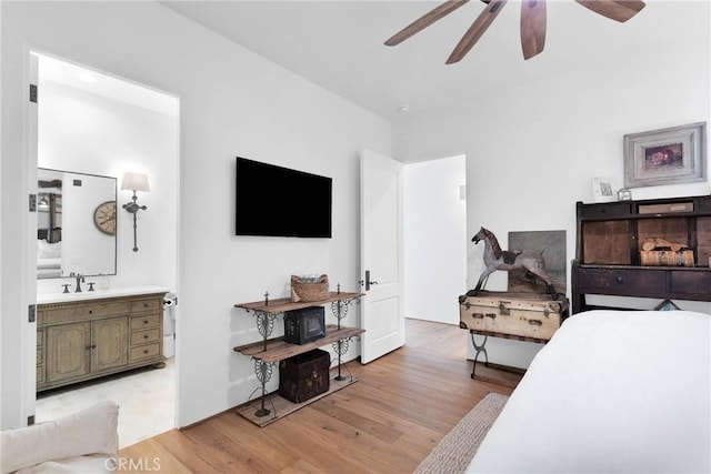 bedroom with sink, light hardwood / wood-style flooring, ceiling fan, and ensuite bathroom