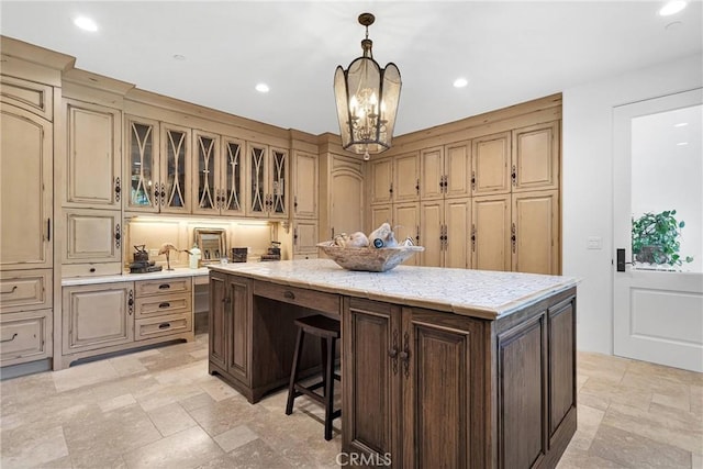 kitchen featuring pendant lighting, a kitchen breakfast bar, a chandelier, and a kitchen island