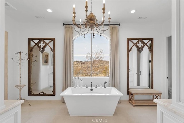 bathroom with a notable chandelier and a tub