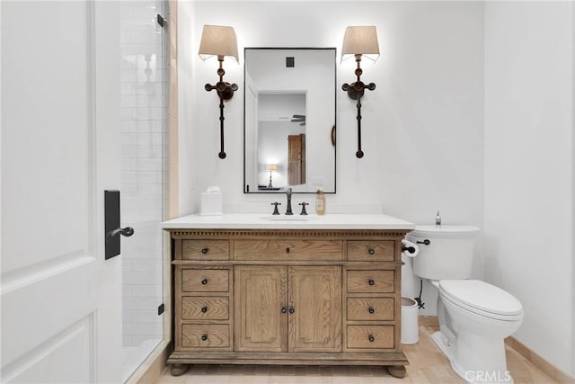 bathroom featuring vanity, toilet, and a tile shower