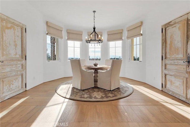 dining area with an inviting chandelier and light hardwood / wood-style flooring