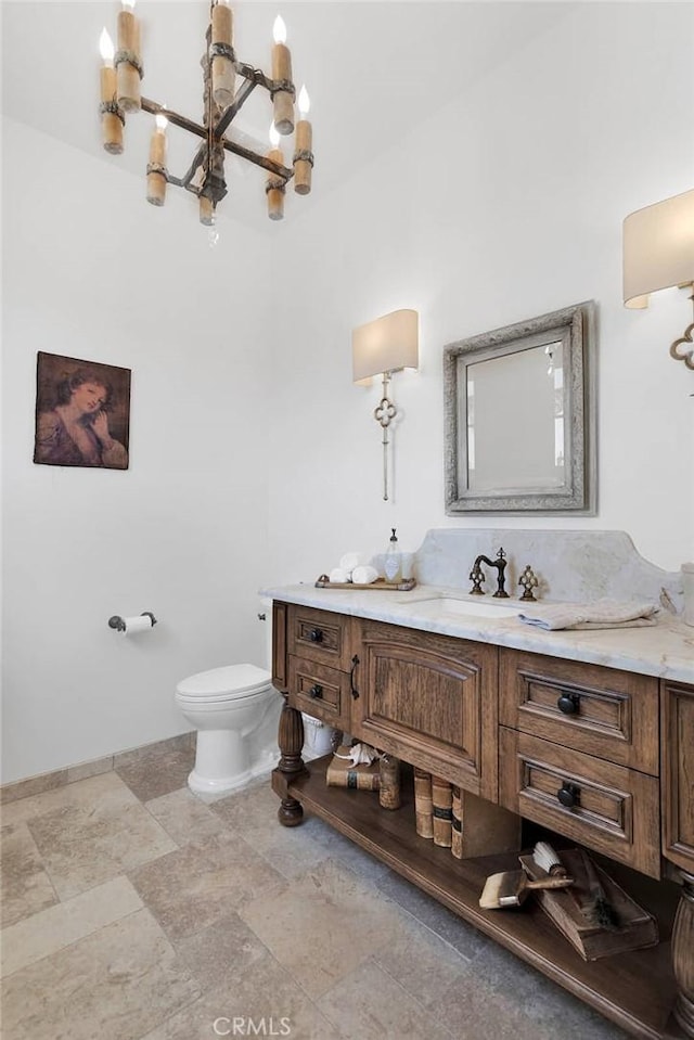 bathroom featuring vanity, a notable chandelier, and toilet