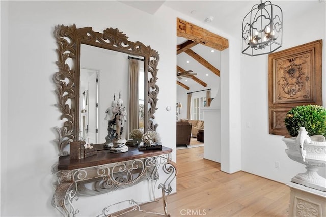 hallway with beam ceiling, an inviting chandelier, and light hardwood / wood-style flooring