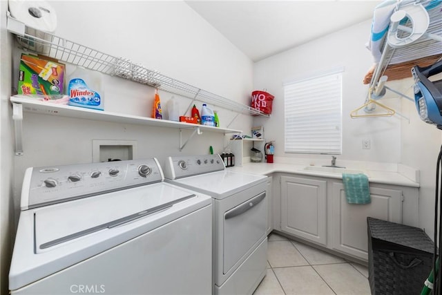 laundry area with cabinets, sink, light tile patterned floors, and washing machine and clothes dryer