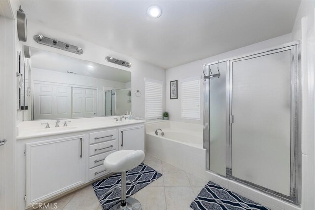 bathroom with tile patterned flooring, shower with separate bathtub, and vanity