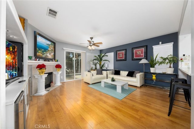 living room featuring ceiling fan, a wealth of natural light, and light hardwood / wood-style floors