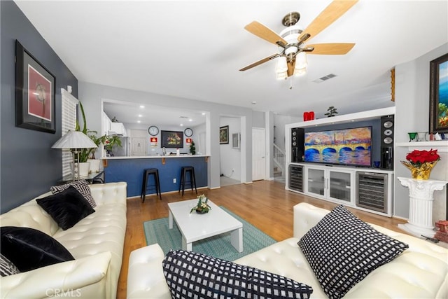 living room with wood-type flooring and ceiling fan