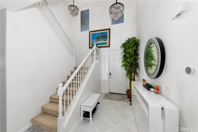 entrance foyer with an inviting chandelier, a high ceiling, and light tile patterned floors