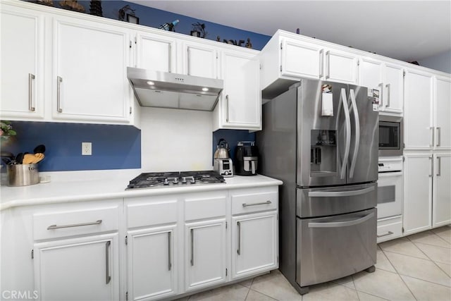 kitchen featuring stainless steel appliances, light tile patterned floors, and white cabinets