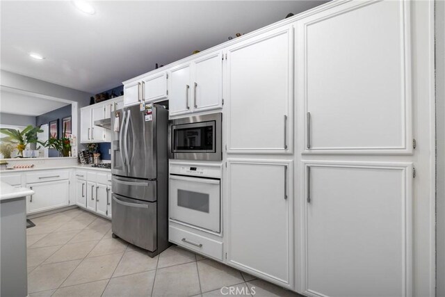 kitchen with white cabinetry, appliances with stainless steel finishes, and light tile patterned flooring