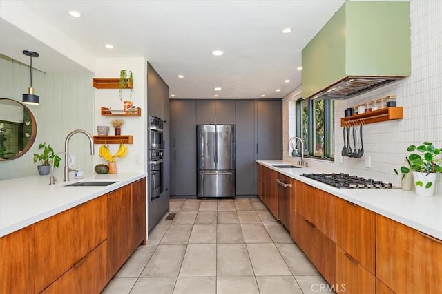 kitchen with appliances with stainless steel finishes, hanging light fixtures, sink, and custom exhaust hood