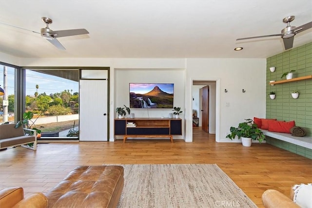 living room with ceiling fan and light wood-type flooring