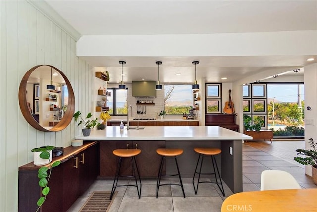 kitchen with sink, a breakfast bar, pendant lighting, and kitchen peninsula